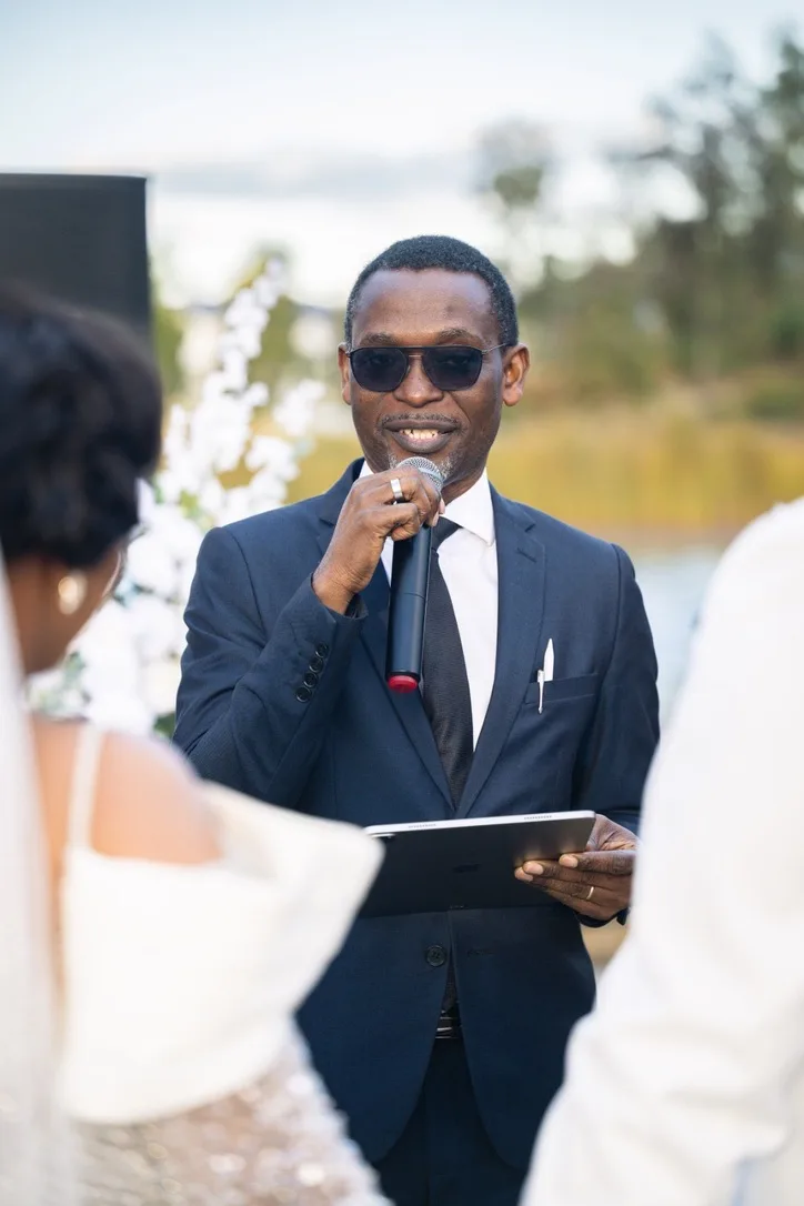 Dr Michaels Aibangbee smiling as he conducts a wedding ceremony outdoors
